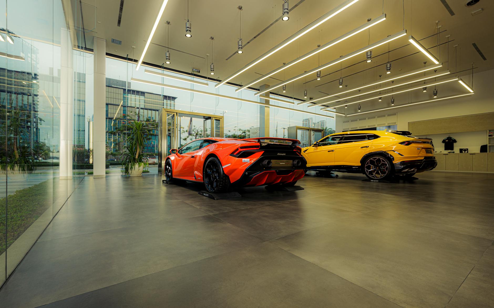 Showroom featuring luxury sports cars, Lamborghini models, with sleek design and modern architecture.