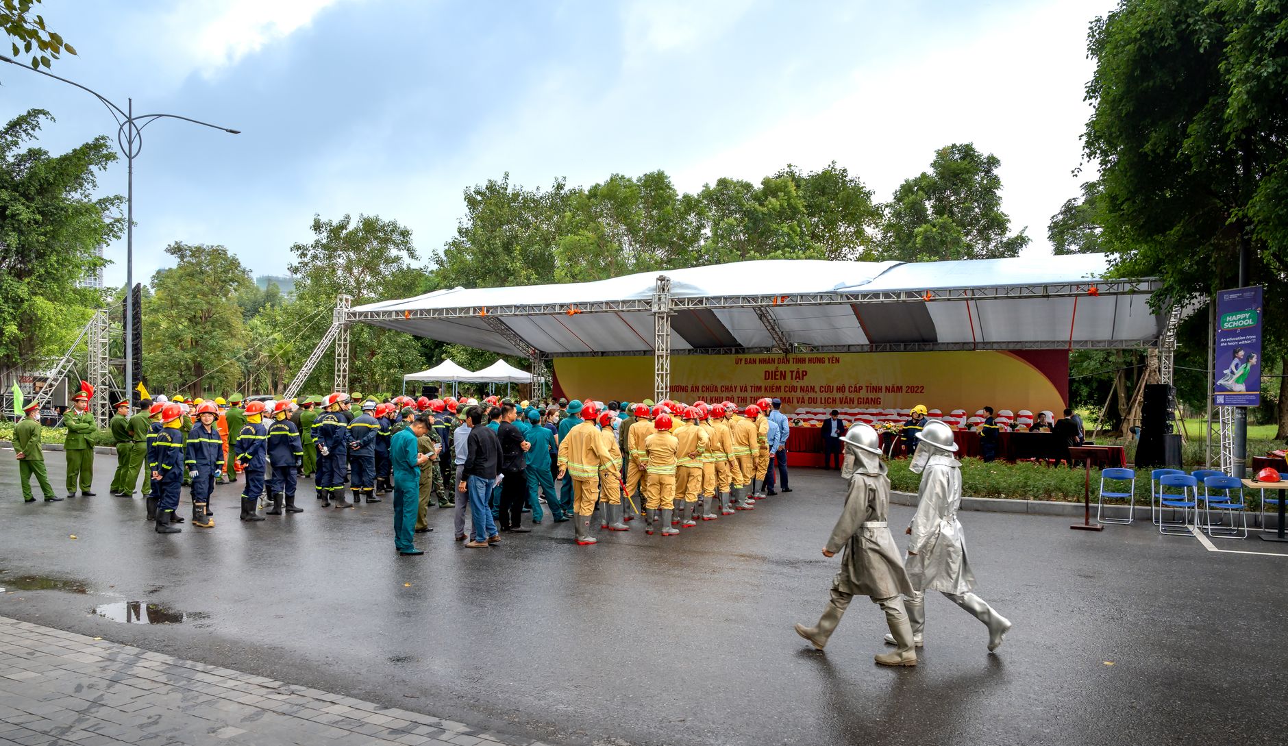 Firefighters in uniform gather for a safety and training event outdoors.