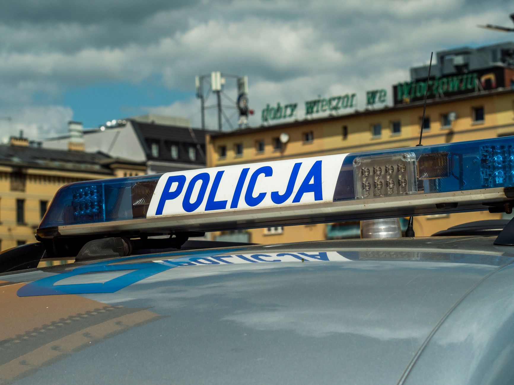 Close-up of Polish police car light bar with buildings in the background.