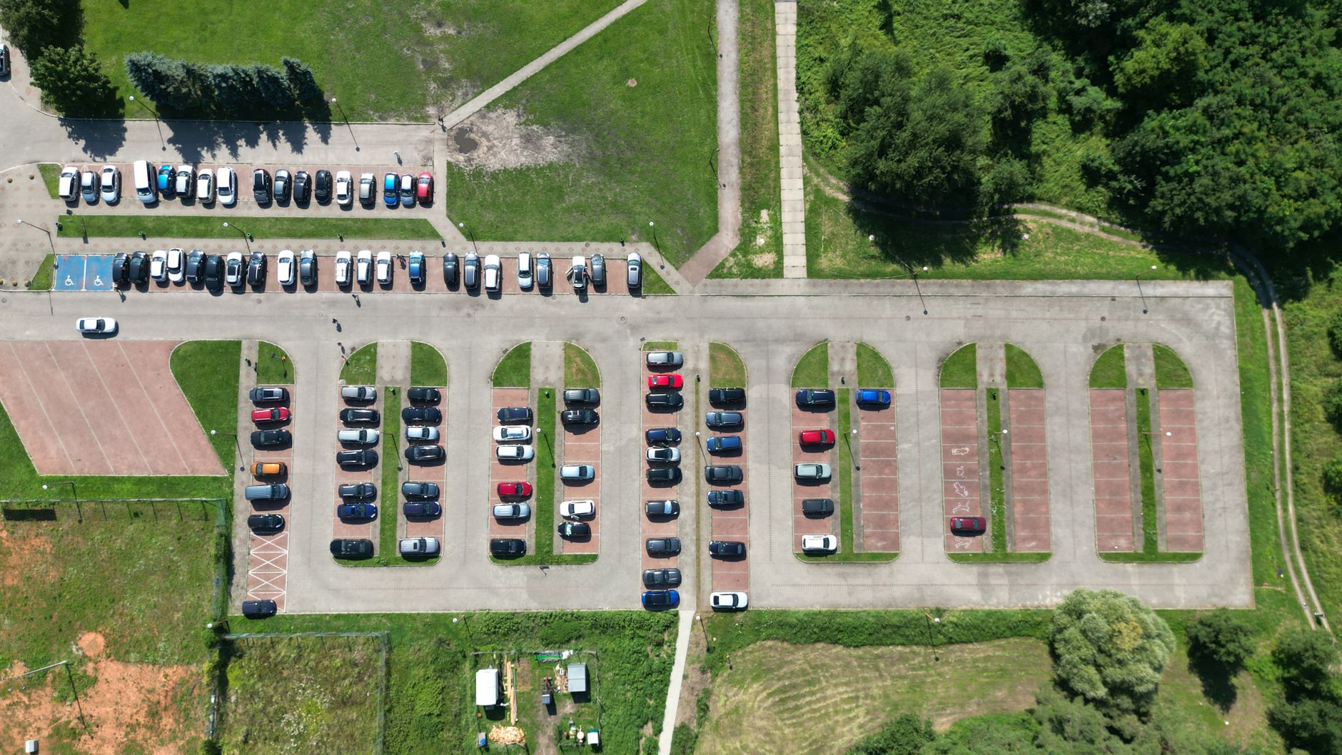 Drone shot of a sunlit parking lot with cars in Gryfino, Poland.
