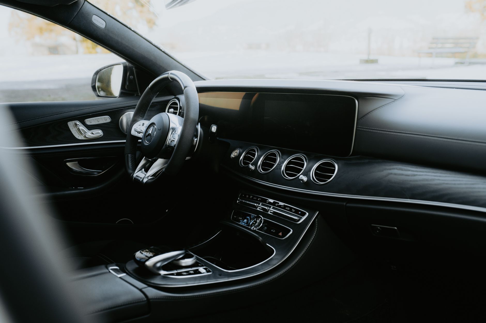 Elegant interior of a black luxury car showcasing a modern dashboard and leather trim.