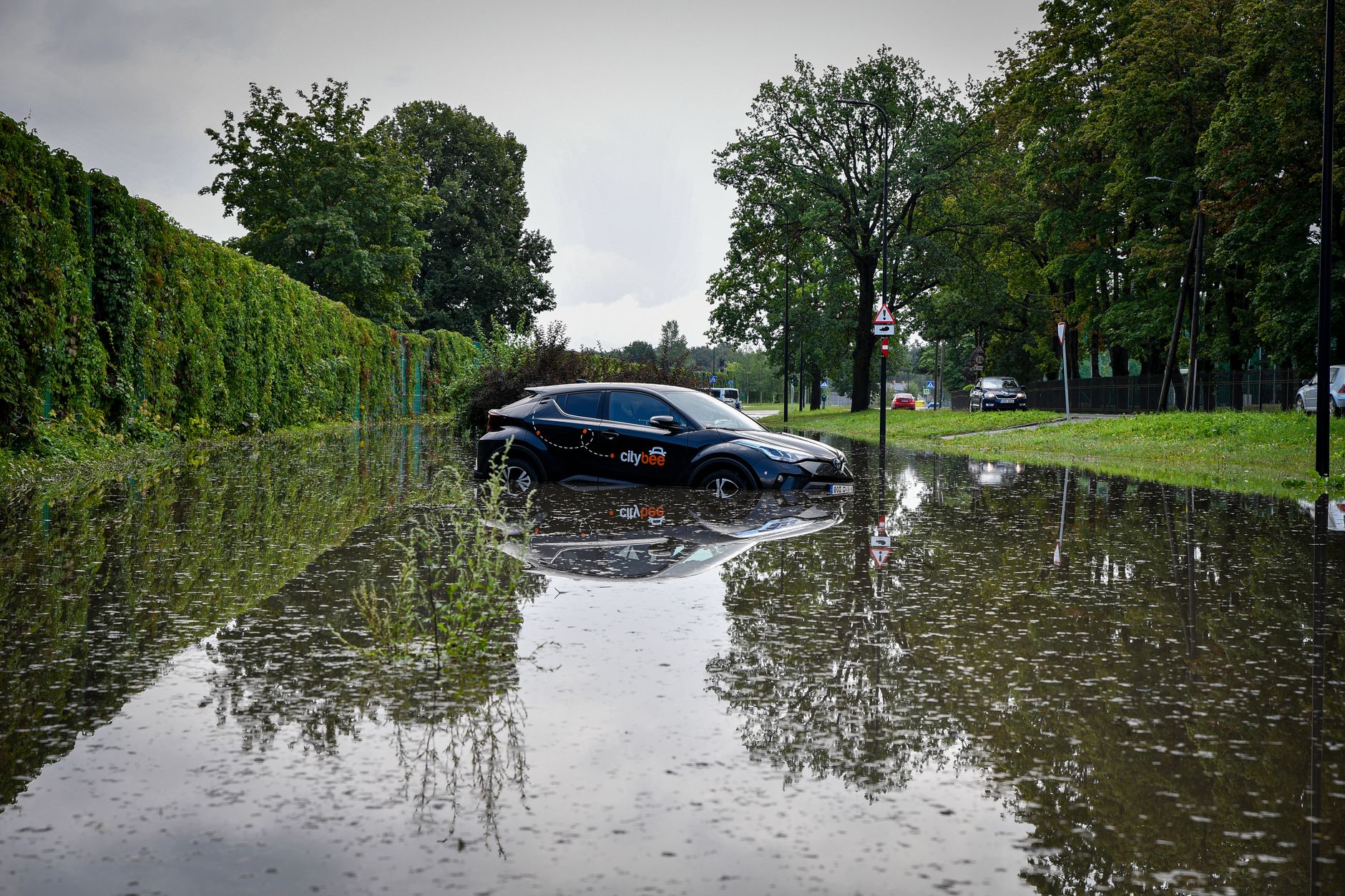 A black car stuck in a flooded street in Tartu, Estonia, after heavy rain.