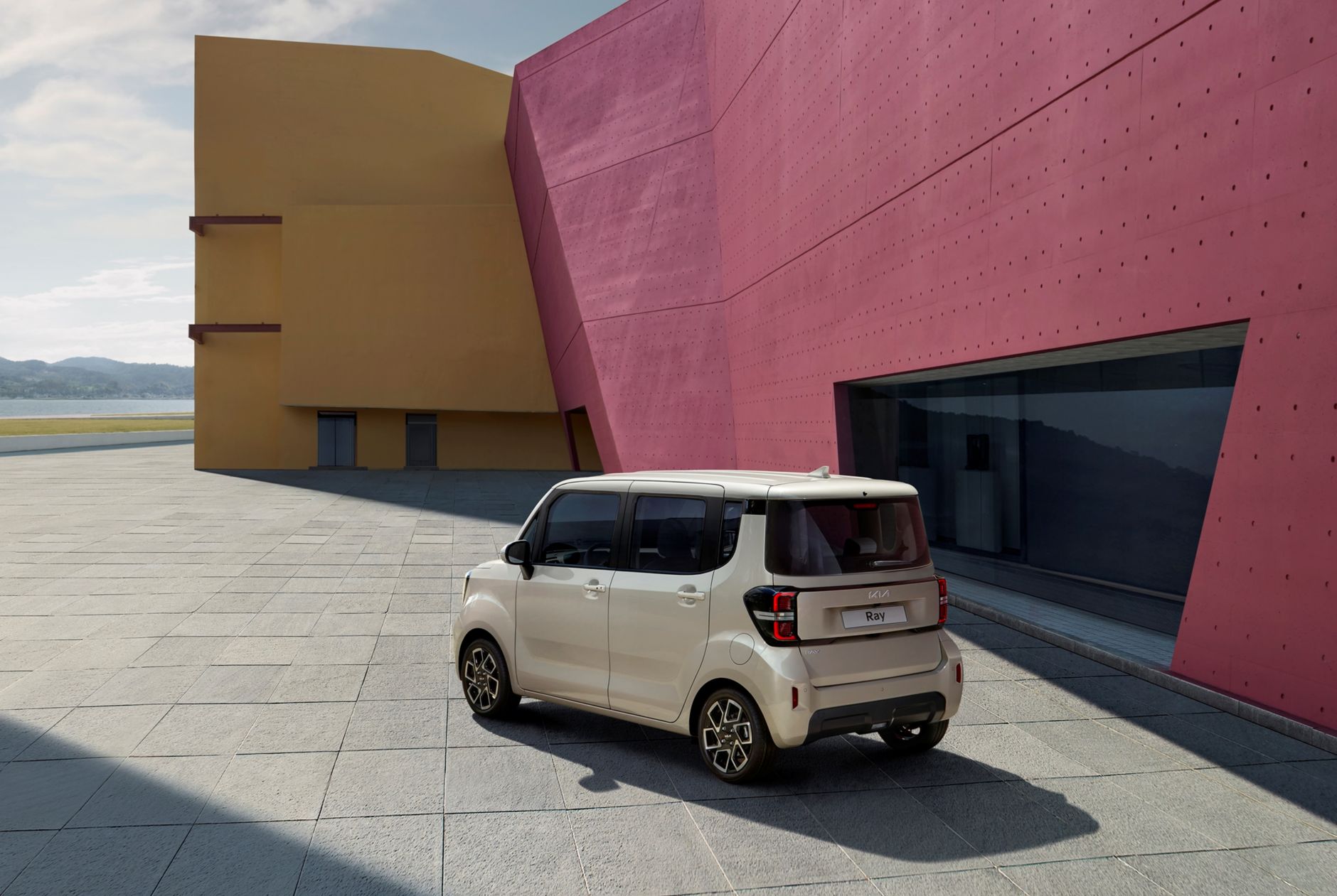 Sleek electric car parked beside colorful modern architecture under daylight.