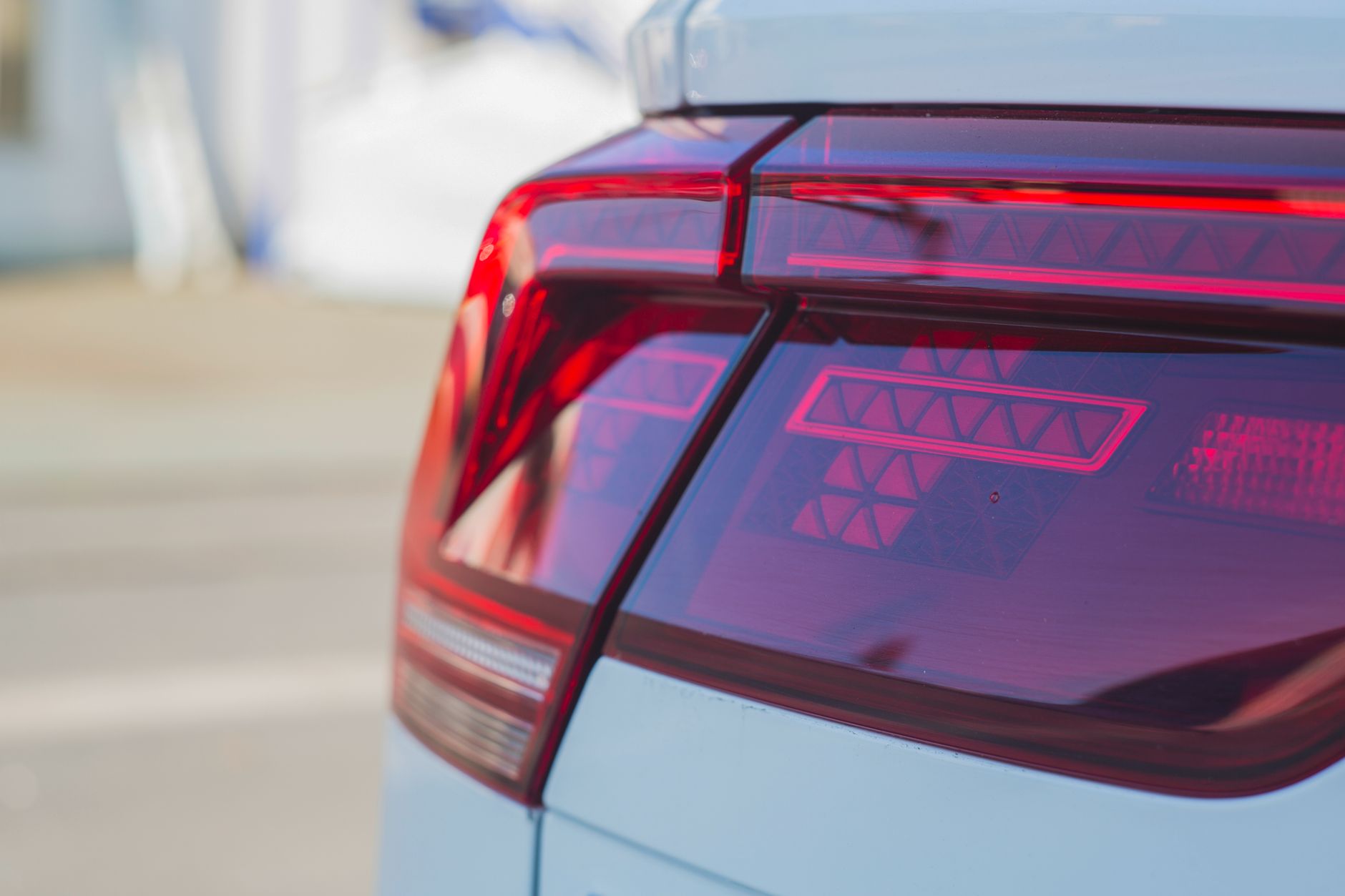 Detailed close-up of a sleek and modern car tail light with red and black tones.