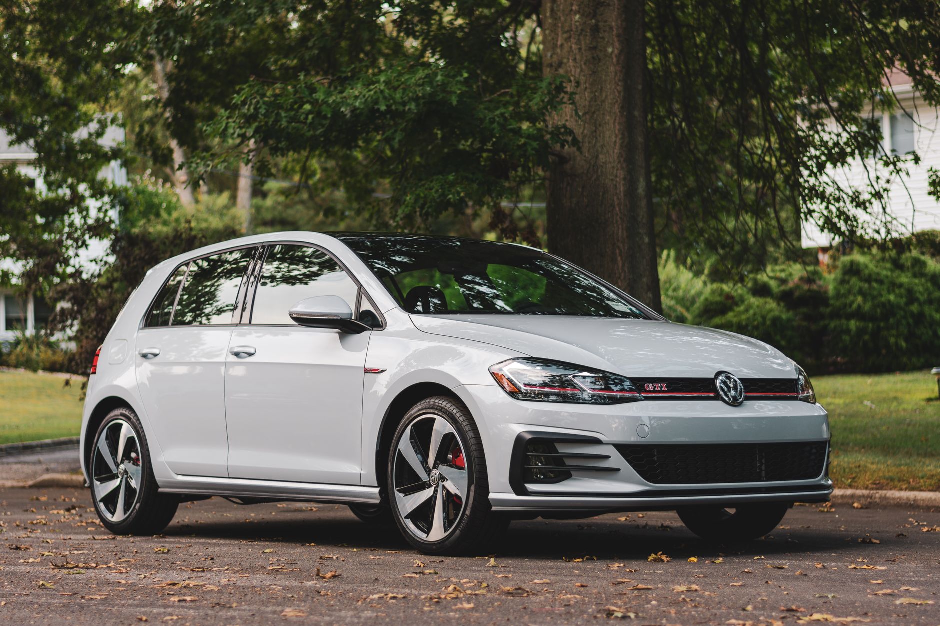 White Volkswagen GTI parked in a scenic outdoor setting, showcasing modern design.