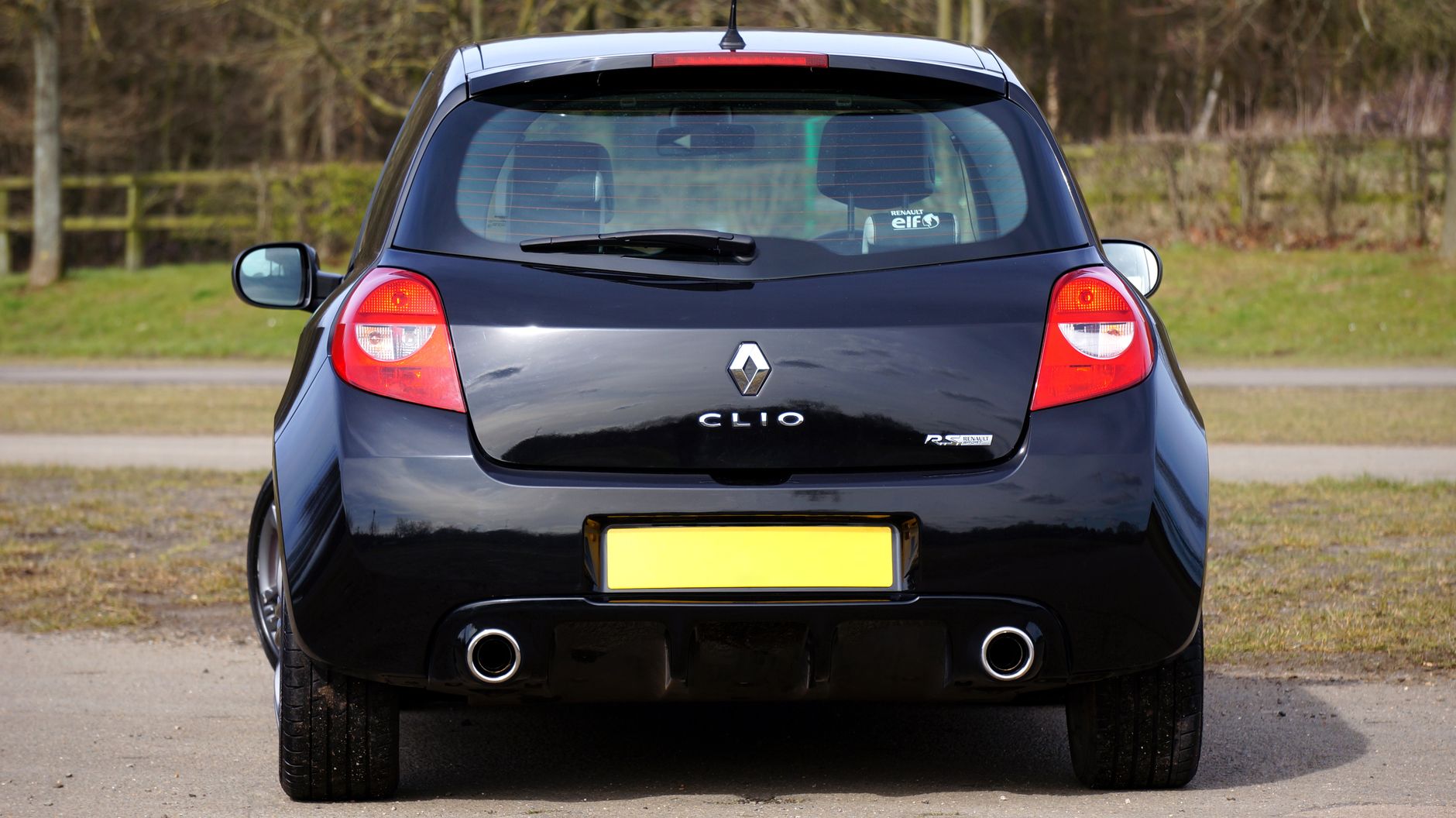A black Renault Clio RS hot hatchback car parked outdoors on a clear day.