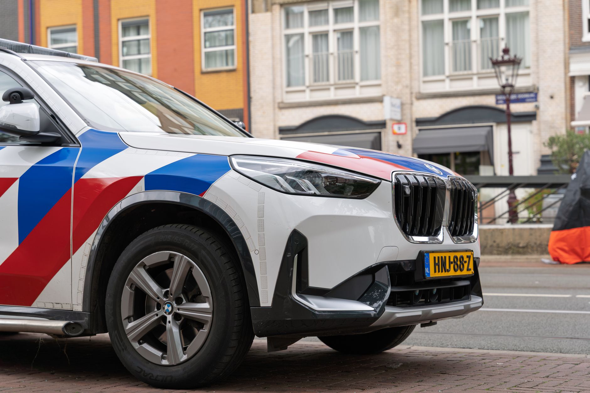 Front view of a modern police vehicle with distinctive markings parked on a city street.