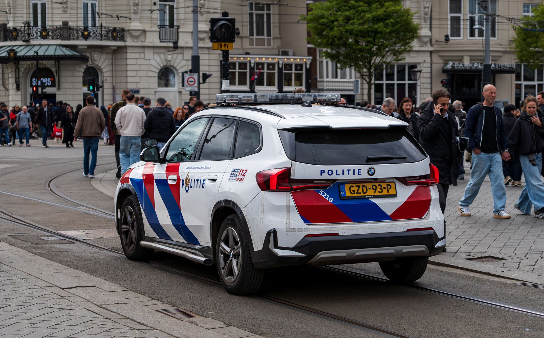 Police car in a busy European city intersection ensuring public safety.