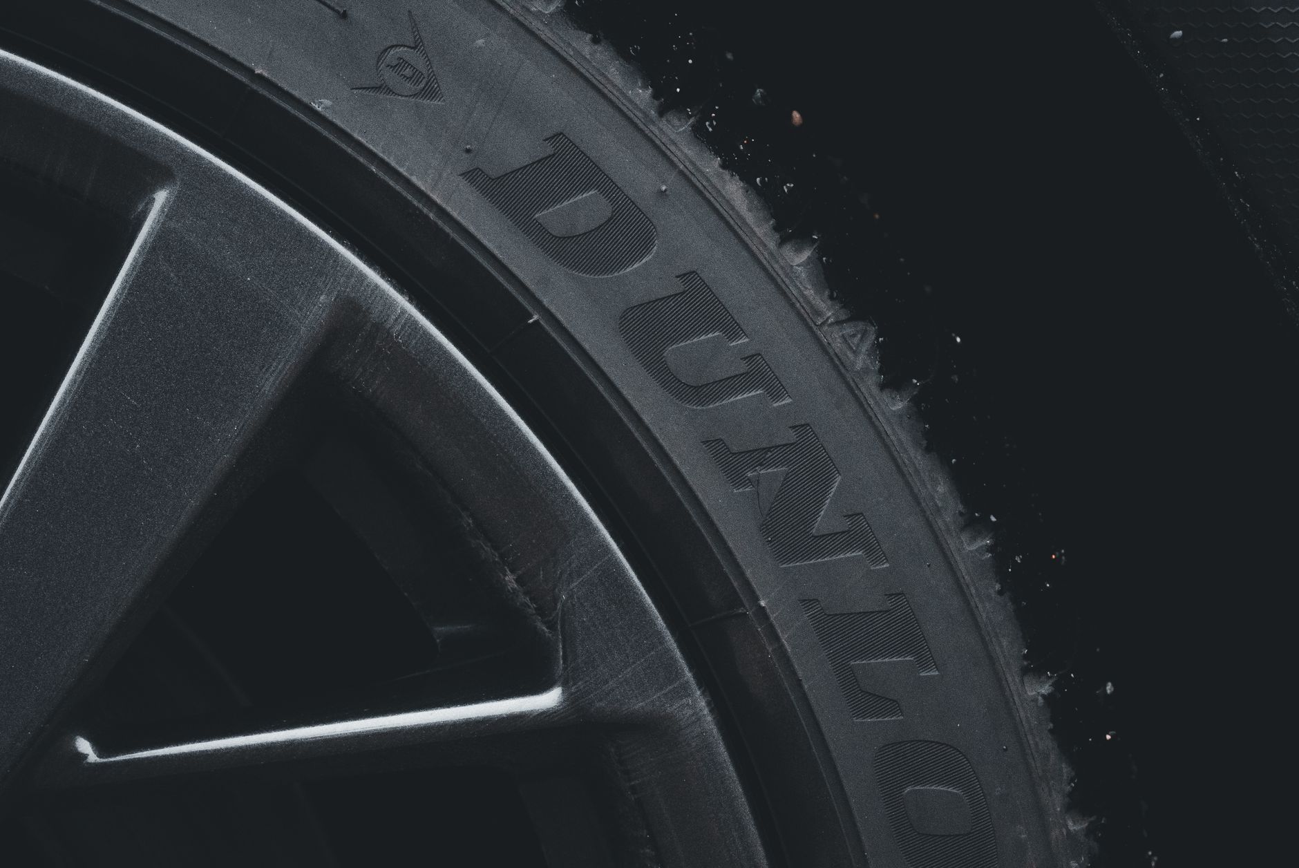 Detailed close-up of a Dunlop tire and rim showcasing its texture and brand text.