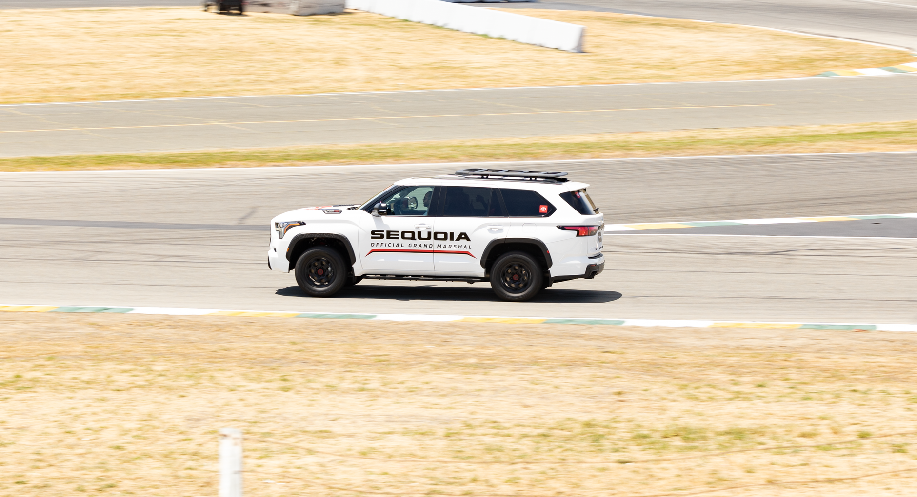 Toyota Sequoia SUV racing on track, showcasing speed and control.