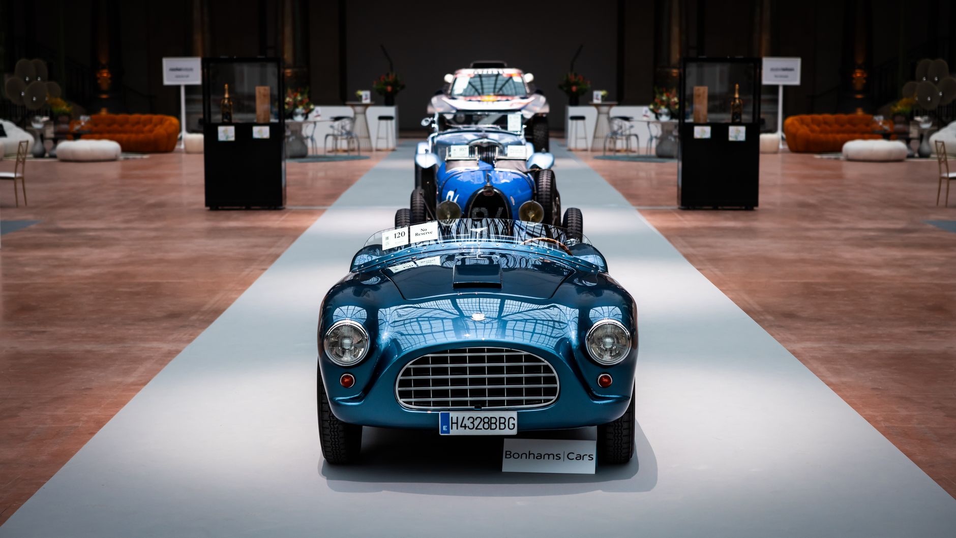 Showcase of classic vintage cars in a stylish indoor showroom setting.